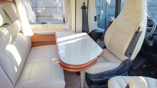 Inneneinrichtung eines Wohnmobils, mit gepolstertem Sofa und Fahrersitz.