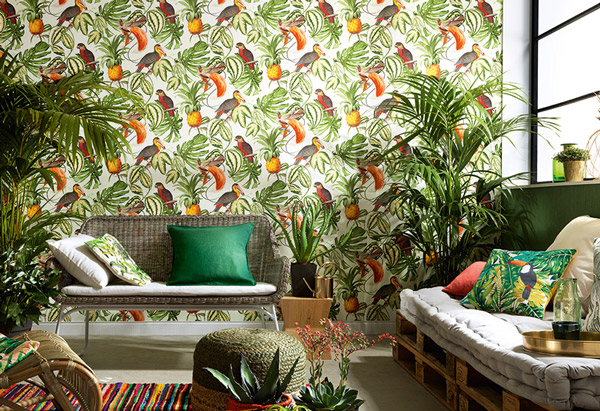 Tropisch eingerichtetes Wohnzimmer mit knalliger Tapete mit Tropenmotiven im Hintergrund.