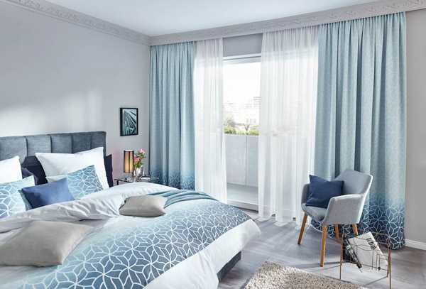Moderner, heller, blau-weißer Wohnraum mit Bett.
