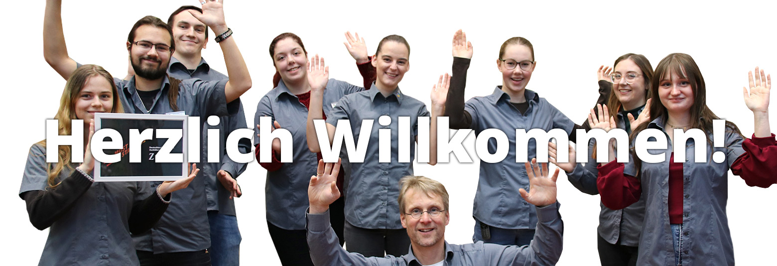 9 Mitarbeiter in einem freudigen Gruppenbild, Text "Herzlich Wilkommen".